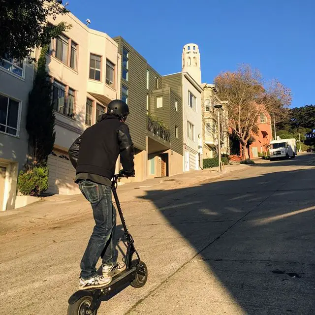 Guy riding electric scooter hill climb